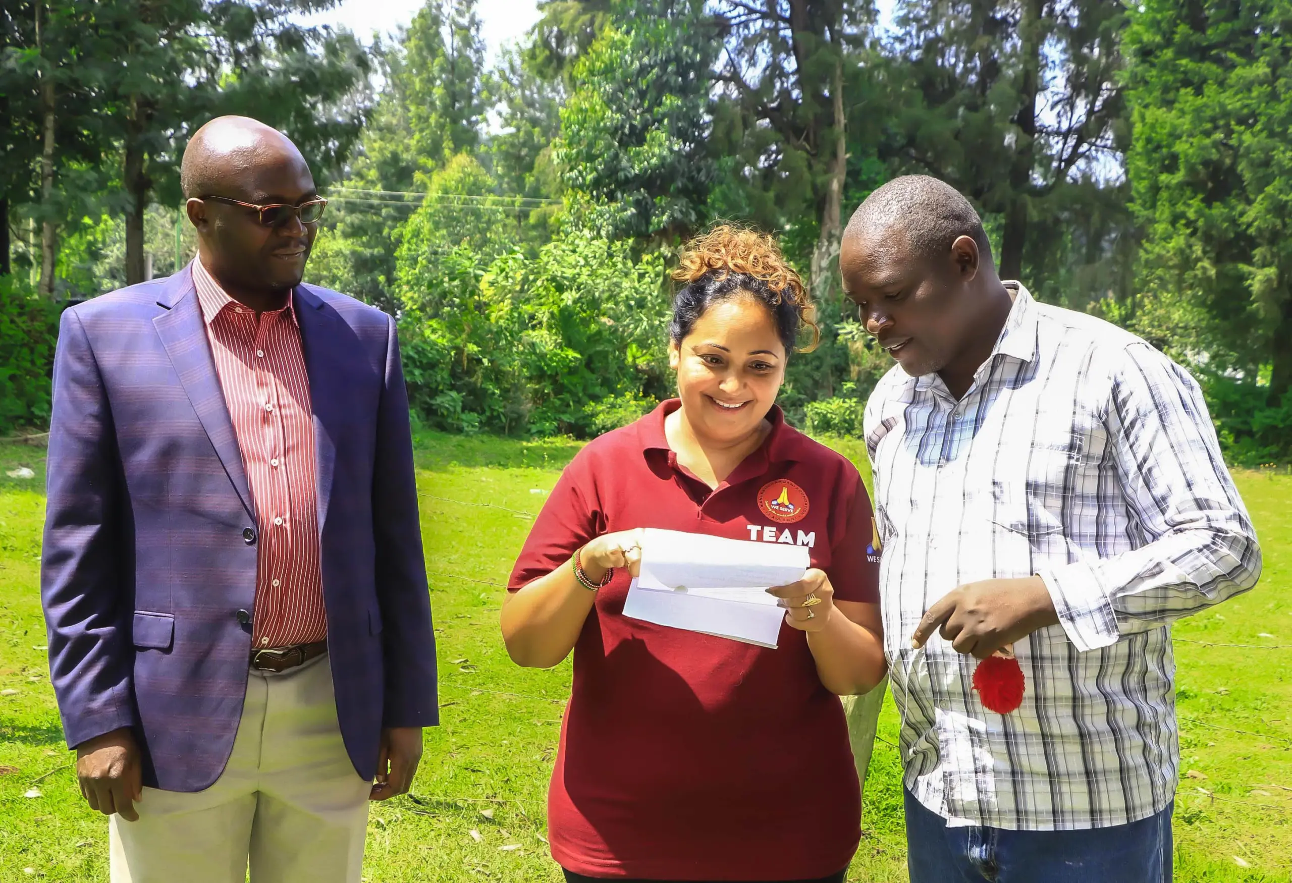 ECAP Founder Douglas Onkeo shows Rani of the Ramichandani Initiative something on paper as Lawyer Philemon Morara Apiemi looks on at Sironga during the event where PLWDs were issued mobility devices. Photo/Arnold Ageta