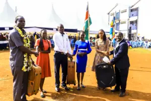 Some of the 2023 class students pose with the suitcases they were gifted, along with their former principal Dr. Erick Wara, a teacher, and the current principal Job Rasugu. Photo/Arnold Ageta