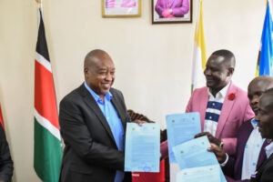 Governor Nyaribo and KNUN officials exchange return to work agreements after ending their four day strike