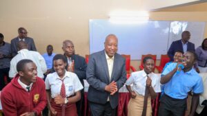 Governor Amos Nyaribo joins students in a celebratory dance at Nyambaria, where he visited them during their mentorship program.