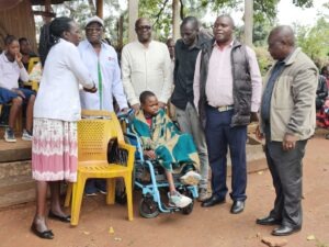 Nelson Apiemi with family members pose for a photo after donating a wheelchair to a child to help with her mobility as she mourns her mother. Photo/Arnold Ageta
