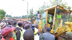 Governor Nyaribo drives a tractor to ceremonially commission road projects in Kemera, aimed at improving the local road network. Photo/Arnold Ageta