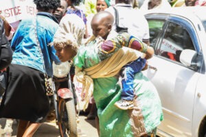 An ECDE teacher carrying her baby on her back and wearing a sack joins striking teachers during the demonstration in Nyamira. Photo/Arnold Ageta