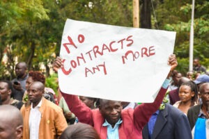 A Nyamira County ECDE teacher holds a “No Contracts Any More” placard during the teachers’ second week of strike. Photo/Arnold Ageta